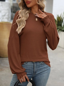 Detailed close-up of smocked cuffs and ribbed texture on the brown long sleeve knit top