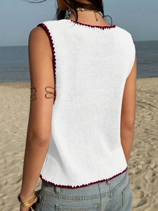 Détail du haut en crochet blanc avec bords festonnés bordeaux et texture tressée