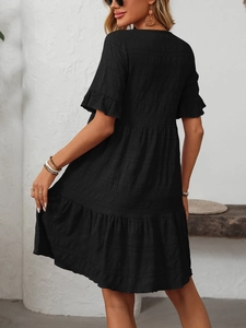 Detail of tiered black bubble texture dress with ruffled sleeves and flowing layers