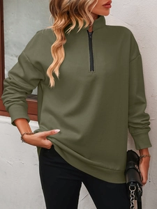 Close-up of olive green quarter-zip sweatshirt with ribbed cuffs and metal zipper detail
