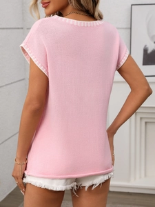 Detail of pink knit top featuring striped trim on sleeves and hem with macro texture