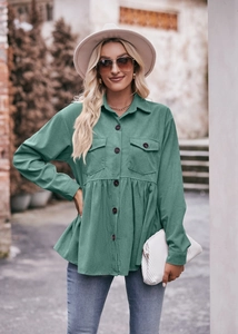 Detail of sage green corduroy babydoll shirt showing ruffle hem and button texture