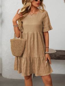 Detail of khaki pleated dress featuring ruffled sleeves and layered skirt design