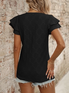 Dettaglio del top nero con scollo a V e trama jacquard a rombi con maniche a volant