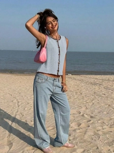 Détail du gilet en tricot bleu clair à bordure crochetée et jean taille haute chic
