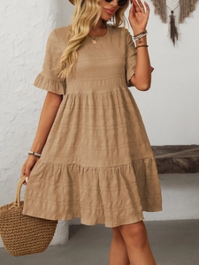 Detail of khaki tiered ruffle dress with short flutter sleeves and textured fabric