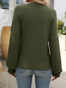 Rear view of long sleeve dark green ribbed knit top featuring delicate ruffled cuffs