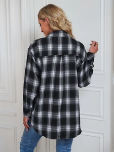 Back view of a loose oversized black and white plaid flannel shirt with a box pleat detail