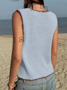 Vue détaillée du dos d'un gilet en tricot bleu clair avec des bords au crochet marron