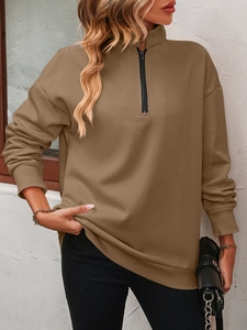 Detail view of khaki half-zip sweatshirt featuring a stand collar and ribbed cuffs