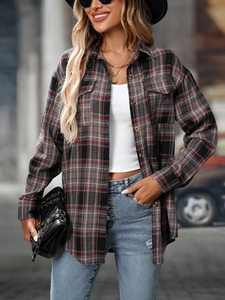 Detail of red and grey plaid shirt featuring classic double chest pockets and long sleeves
