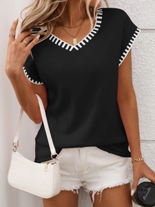 Close-up of black V-neck knit top with striped hem detail and textured fabric finish