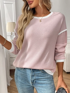 Detail of pink knit top with white contrast ribbed stitching on shoulder and neckline