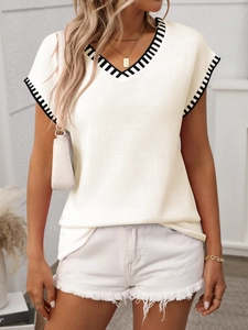 Detail of V-neck knit sweater vest featuring classic black and white striped trim edges