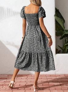 Rear view of floral tiered dress featuring elastic smocked back and ruffled sleeves
