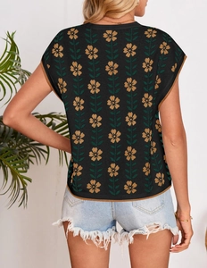 Detail of knit crop top featuring yellow floral patterns and brown contrast trim edges