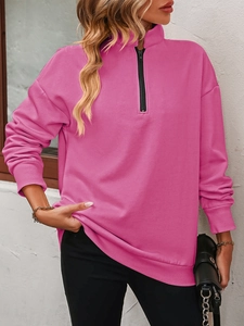 Detail of rose red fleece sweatshirt featuring a half-zip stand collar and ribbed cuffs
