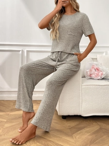 Detail of grey ribbed knit loungewear set featuring drawstring pants and soft texture