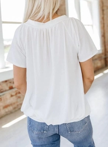 Detailansicht der Rückseite des weißen Baumwoll-T-Shirts mit elegantem Plissee-Design