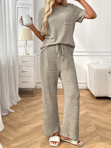 Close-up of gray ribbed knit loungewear set featuring drawstring pants and chest pocket