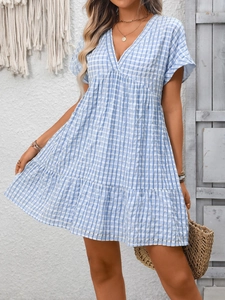 Detail view of a V-neck blue gingham babydoll mini dress with ruffled hem for summer