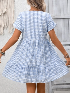 Detail of blue and white plaid babydoll dress with layered tiered hem and short sleeves