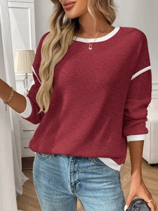 Detail of dark red ribbed knit sweater with white contrast piping on neckline and cuffs
