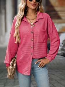 Detail of rose pink waffle knit shirt featuring texture, polo collar and brown buttons