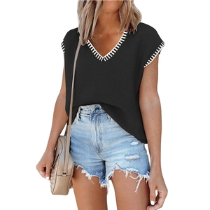 Women's black V-neck knitted vest sweater with white sawtooth trim on plain background