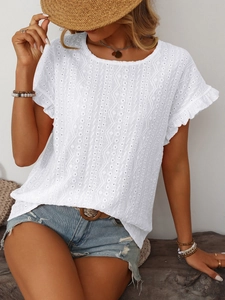 Détail du haut en coton blanc avec broderie anglaise et motifs géométriques