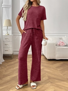 Detail of burgundy ribbed knit fabric texture on short sleeve top and drawstring pants
