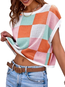 Dettaglio del crop top in maglia a scacchi con motivo color block arancio rosa e verde