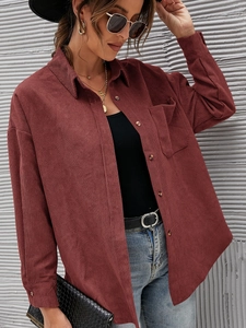 Detailed texture of burgundy corduroy shirt featuring amber buttons and ribbed fabric