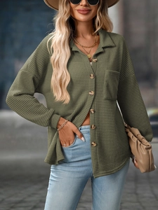 Detail of army green waffle knit shirt showing textured fabric and amber buttons