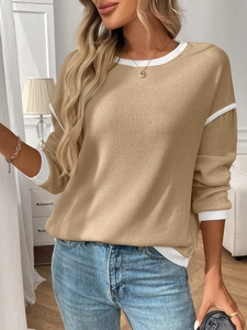Detail shot of khaki knit sweater showing white contrast ribbing on cuffs and hem