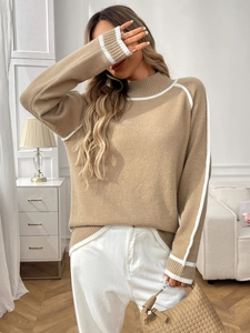 Détail du poignet du pull en maille kaki avec rayures blanches et texture côtelée