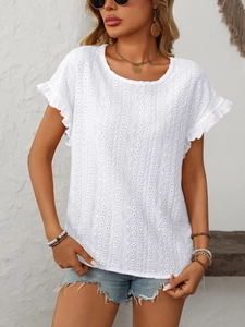 Détail d'un haut blanc à manches courtes avec broderie anglaise et poignets volantés