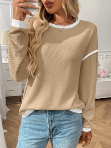 Detailed texture of khaki ribbed knit sweater with white contrast stitching on seams