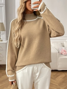 Détail d'un pull en maille kaki avec rayures blanches contrastées et col montant chic