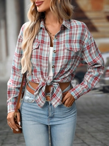 Detail of red and blue plaid shirt featuring flap pockets and casual knotted hem design