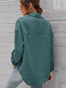 Detailed back view of an oversized dark green corduroy shirt showing its ribbed texture