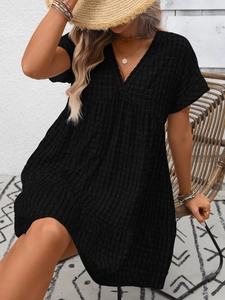 Detailed shot of black V-neck plaid dress fabric texture and casual bohemian summer style