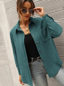 Close-up of dark green corduroy shirt showing classic collar and wood-textured buttons