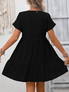 Detail of black plaid tiered dress with textured waffle fabric and back view on model