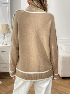 Vue arrière d'un pull en maille camel avec rayures blanches dans un intérieur chaleureux
