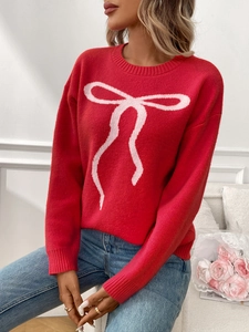 Detailed view of the red knit sweater featuring a white bow jacquard and ribbed cuffs