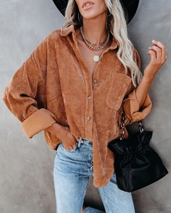 Detail of oversized corduroy shirt texture with chest pocket in caramel brown