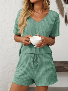 Détail d'un ensemble homewear vert clair en maille côtelée avec haut col V et short à cordon