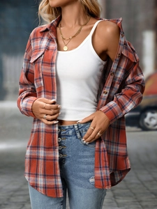 Close-up of flannel plaid shirt layered with white ribbed tank top and blue denim jeans