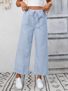 Dettaglio dei pantaloni a righe bianche e blu con coulisse in vita e orlo con risvolto